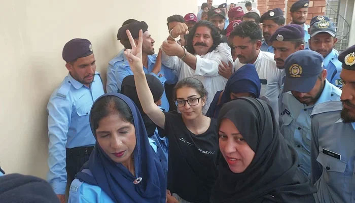 Human rights lawyer Imaan Mazari (bottom centre) and PTI leader Ali Wazir being escorted to a court by Islamabad police on August 20, 2023. — Twitter