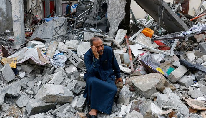 A Palestinian sits on the rubble of a building destroyed in Israeli strikes, in Rafah in the southern Gaza Strip on October 9, 2023. — Reuters