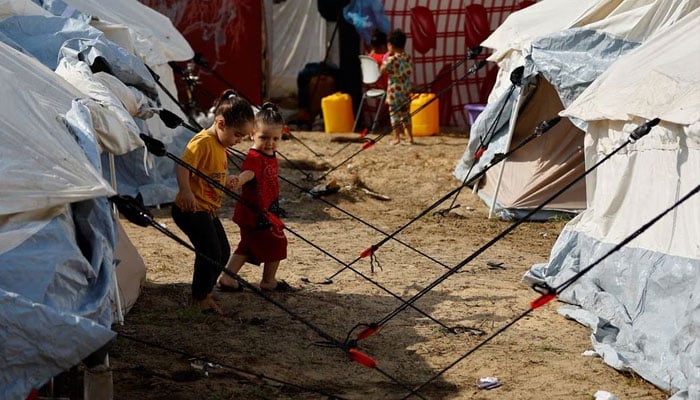 [4/13]Displaced Palestinian kids, who fled their houses amid Israeli strikes, take shelter in a tent camp at a United Nations-run centre in Khan Younis in the southern Gaza Strip, October 24.—Reuters