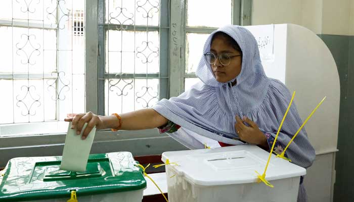 A woman reaches out to a ballot box to cast a vote at a polling station during the general election in Karachi, Pakistan February 8, 2024. —Reuters