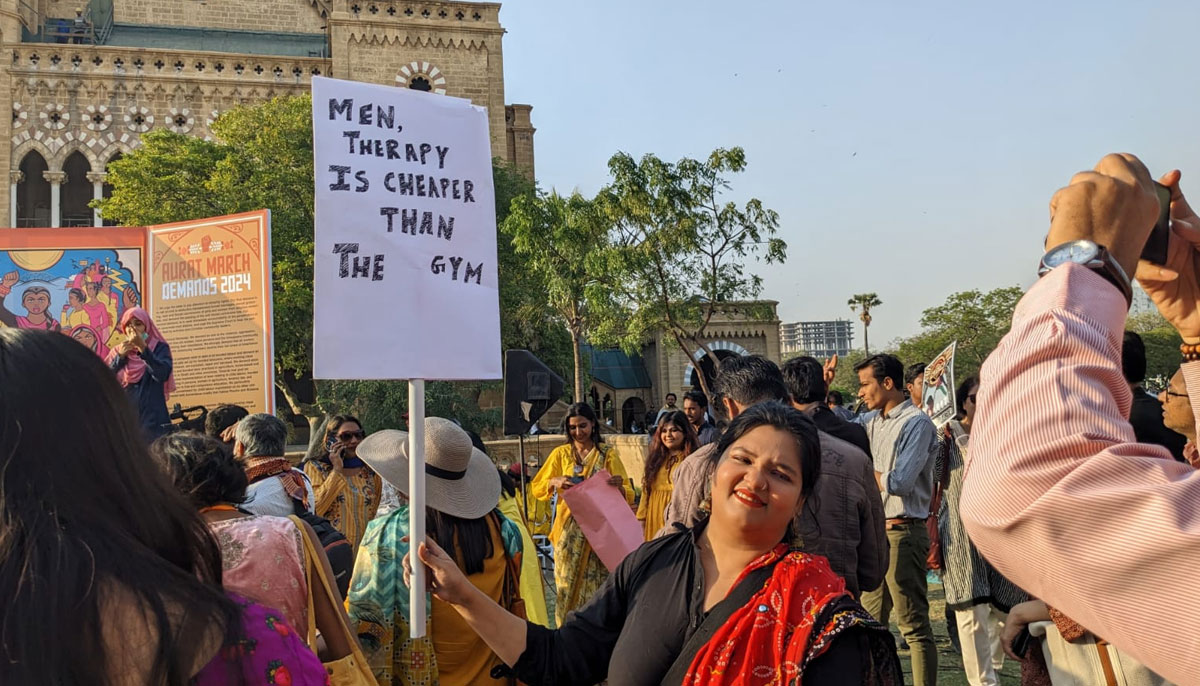 A woman holding a placard in Aurat March at Frere Hall Karachi on March 8, 2024. — Author
