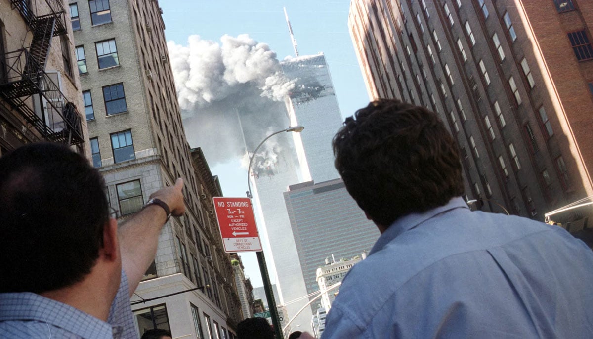 Pedestrians react to the World Trade Center collapse, September 11, 2001. — Reuters