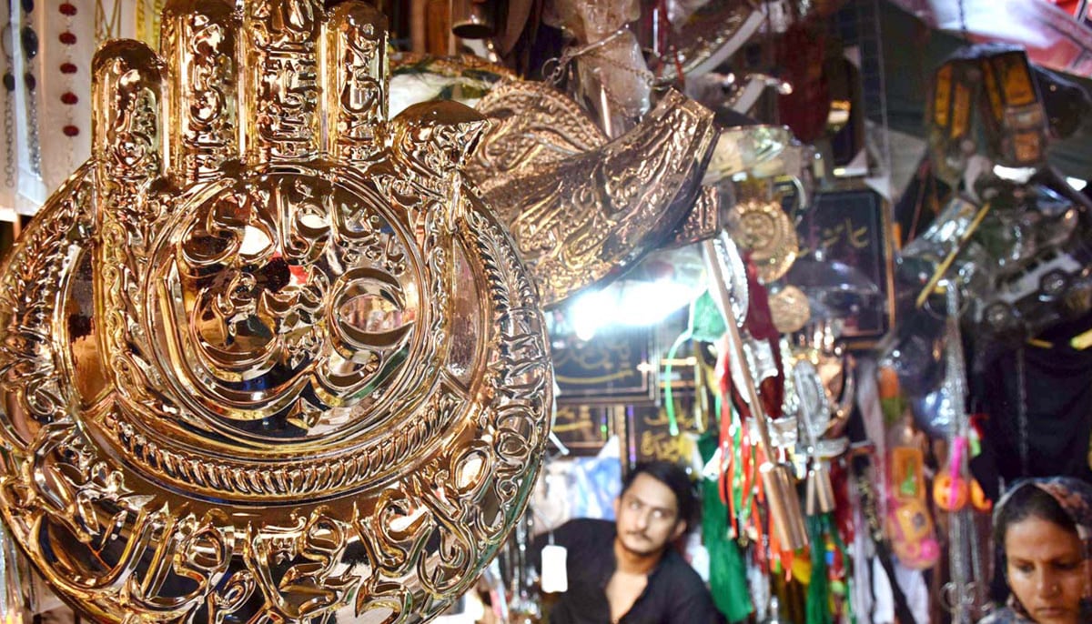 A shopkeeper displays Muharram-related artefacts to attract customers in Lahore, on July 14, 2024. — APP