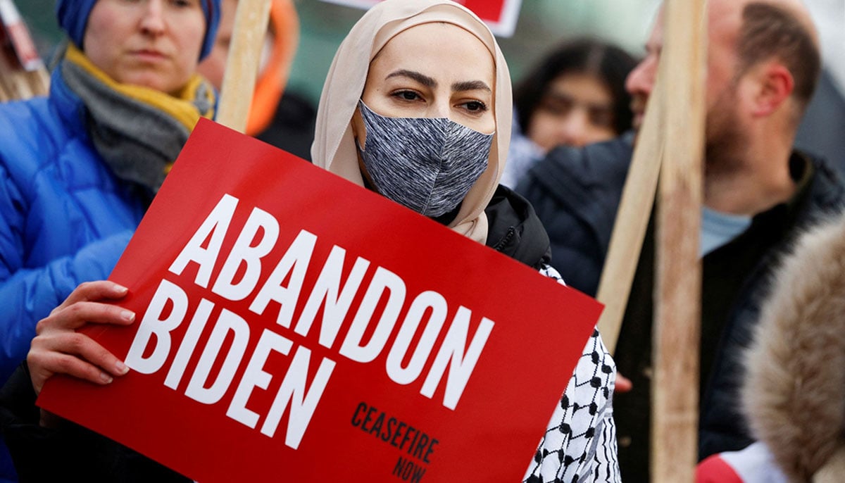 A Muslim woman stands with a Abandon Biden, Ceasefire Now sign during a protest calling for Biden administration to push for a permanent ceasefire in Gaza and condition aid to Israel. — X/@Reuters