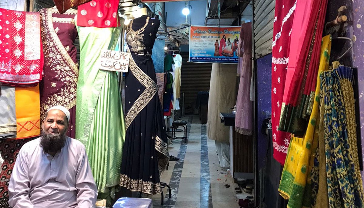 Chaapa fabric seller Jamal is seated at his shop in the Hyderi market, Karachi. — Photo by author