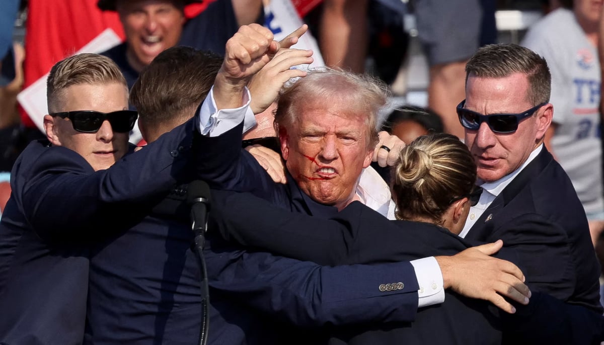 Then Republican presidential candidate Donald Trump is assisted by the Secret Service after gunfire rang out during a campaign rally at the Butler Farm Show in Butler, Pennsylvania, US on July 13, 2024. &mdash; Reuters