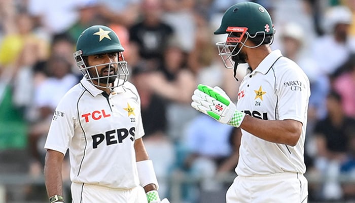 Pakistans Babar Azam (L) and Shan Masood (R) talk between overs during the third day of the second international Test cricket match between South Africa and Pakistan at Newlands stadium in Cape Town on January 5, 2025. — AFP