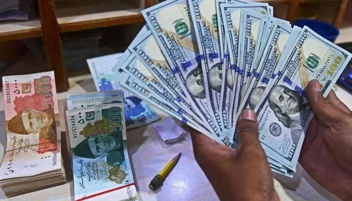 A foreign currency dealer counts US dollars at a shop in Karachi, May 19, 2022. — AFP