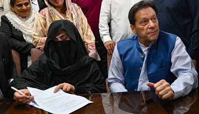 Former prime minister Imran Khan along with his wife Bushra Bibi as she signs surety bonds for bail in various cases, at the registrars office in the Lahore High Court. — AFP/File