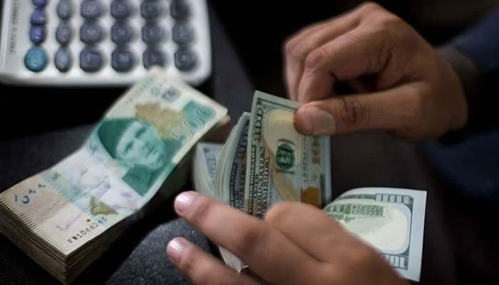 A representational image of a currency dealer counting $100 notes. — AFP/File