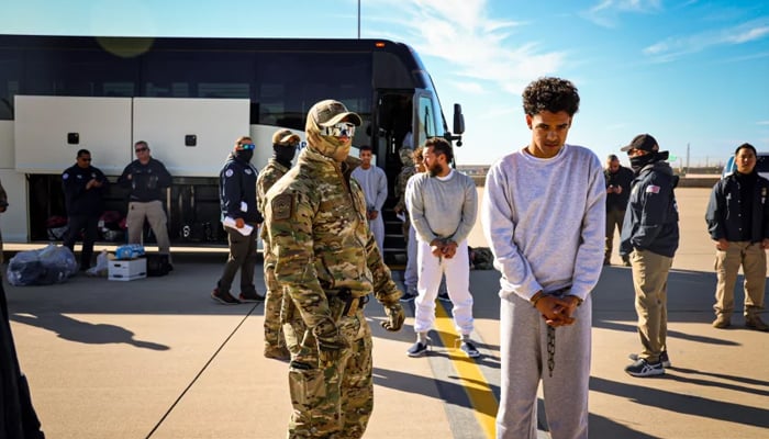 An undated photo released by the US Department of Homeland Security shows migrants as they boarded planes for Guantanamo Bay, Cuba. — DHS