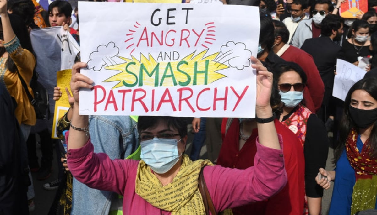 Aurat March activists hold placards during a demonstration to mark the International Womens Day in Lahore on March 8, 2022. — AFP