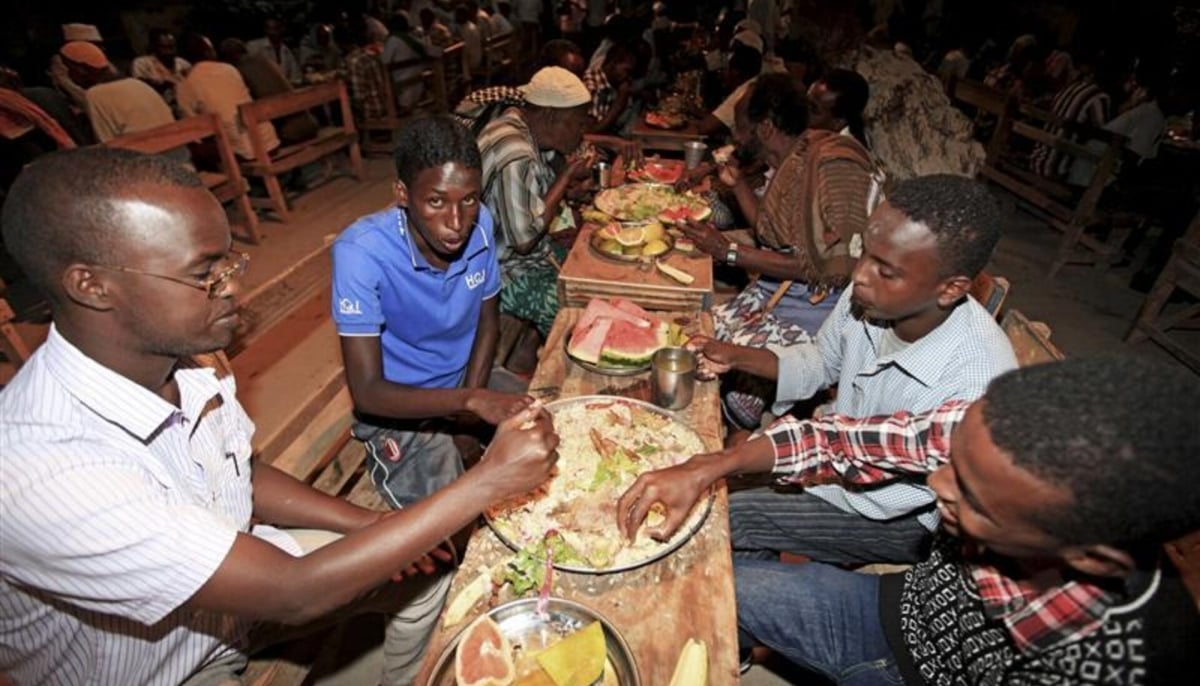 Somali Muslim men eat during iftar, as they break their fast, at the African Muslim agency during the holy month of Ramadan in Somalias capital Mogadishu. — Reuters