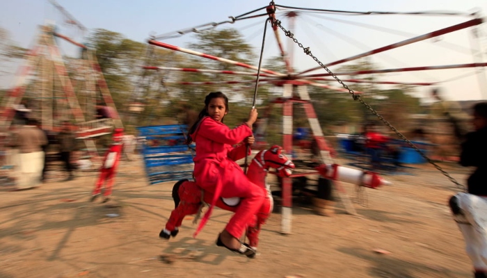 A girl rides on a makeshift merry go round on Christmas Day in Islamabad. — Reuters
