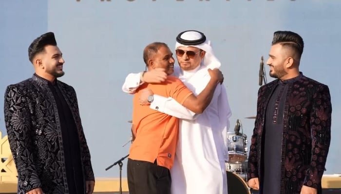 A worker hugs Major General Obaid Muhair bin Suroor, assistant director-general of GDRFA Dubai, after receiving a gold bar at the grand Eid celebration event for workers in Dubai, UAE. — Reporter