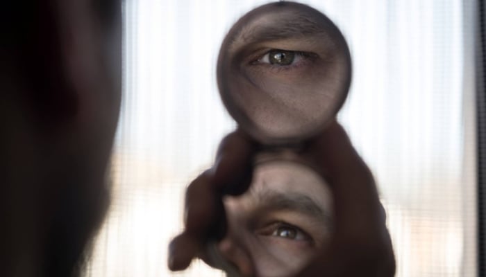 A person is looking into hand mirror. — Reuters/ File