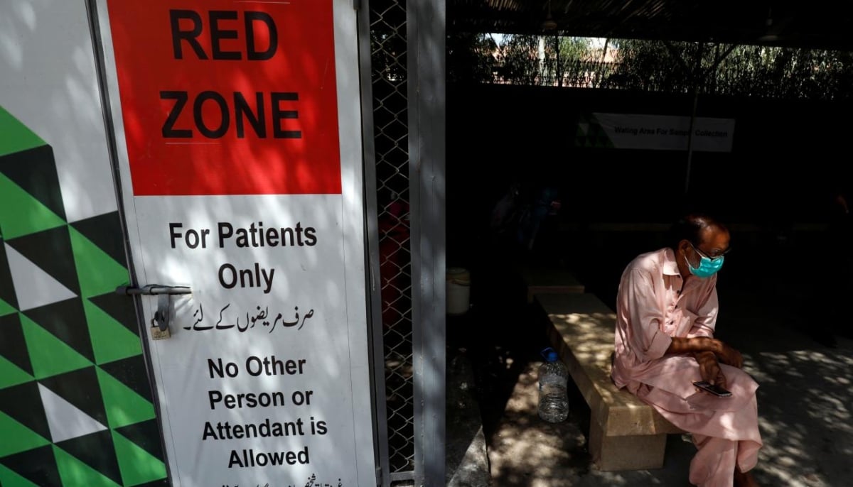 A man sits at the waiting area outside a sample collection facility for the coronavirus disease testing in Karachi on June 19, 2020. — Reuters