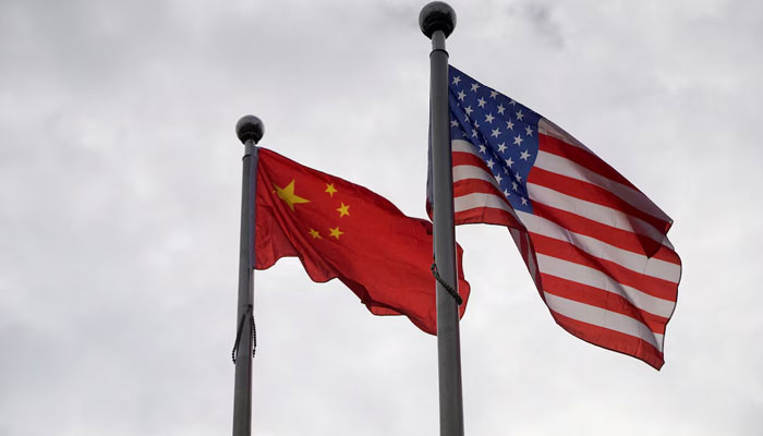 Chinese and U.S. flags flutter outside a company building in Shanghai, China November 16, 2021. — Reuters