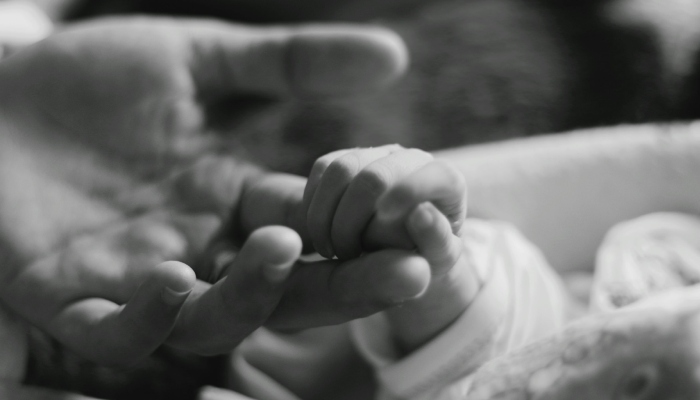 This representational image shows a baby holding an adults finger. — Unsplash
