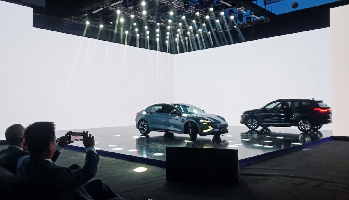 An attendee takes photos of the Chinese electric vehicle BYD models on display, during an event to announce the plans to open a car production plant in Pakistan, in Lahore on August 17, 2024. — Reuters