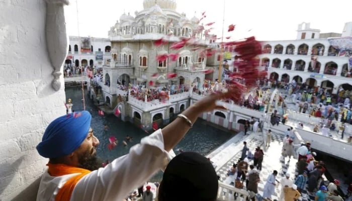 An undated image shows a Sikh devotee throwing petals as the procession passes by during the Baisakhi festival at Panja Sahib shrine in Hassan Abdal. — Reuters/File
