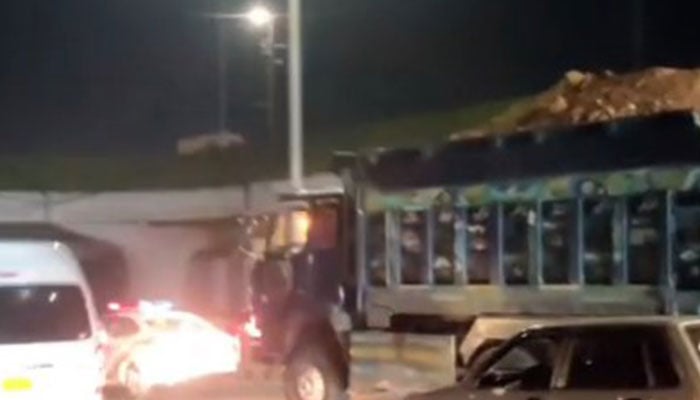 A traffic police vehicle attempts to stop a dumper on Karachis Sharea Faisal. — Reporter