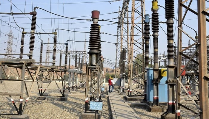 Technicians work at a power grid station in Faisalabad. — AFP/File