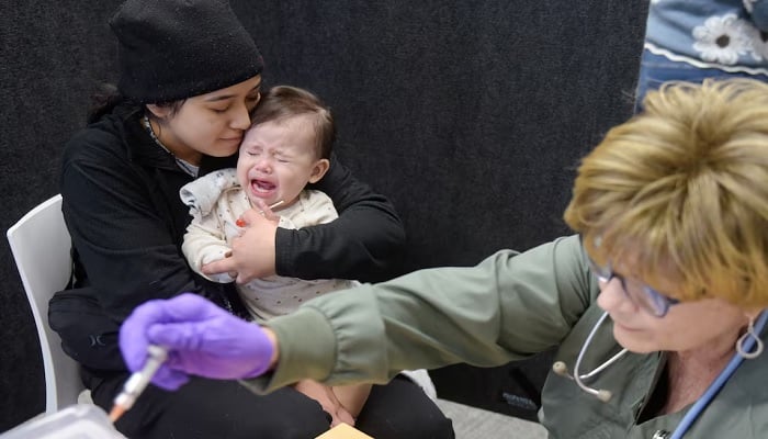 Devonay Pena comforts her 13-month-old daughter, Jaqi Herrera, after Herrera received her first dose of the MMR vaccine at the City of Lubbock Health Department in Lubbock, Texas, US, February 27, 2025.— Reuters