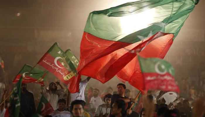 Supporters of Imran Khan wave their partys flag during an election campaign rally in Lahore, May 5, 2013. — Reuters