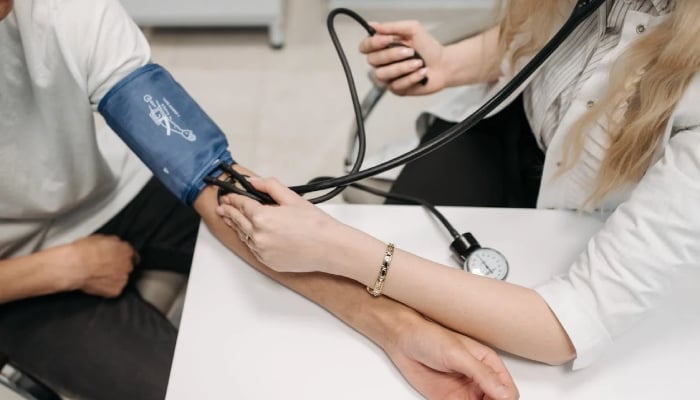 This representational image shows a doctor checking a patients blood pressure. — Pexels