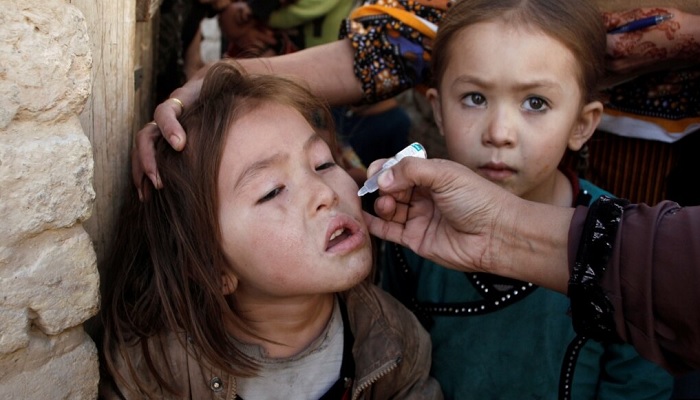 A girl receives polio vaccine drops from a vaccination worker outside her familys home in Quetta. — Reuters