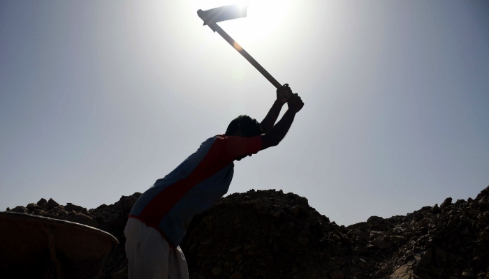 A labourer uses an axe at a work site in Karachi. — Online/File