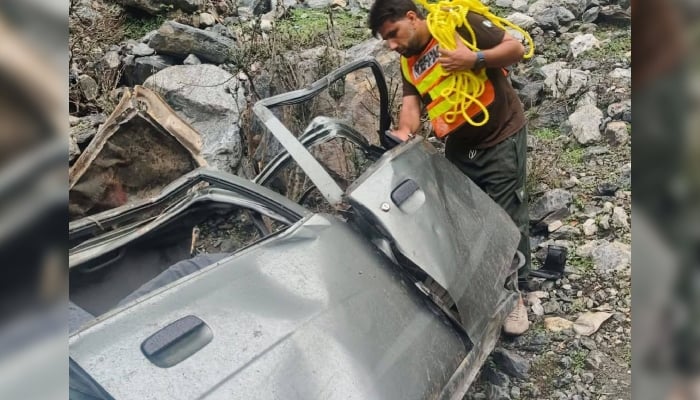 Rescue official inspects the wreckage of the car which plunged into a ravine in the Matta Banda area of Lower Kohistan on May 1, 2025. — Facebook@ERSUpperKohistan