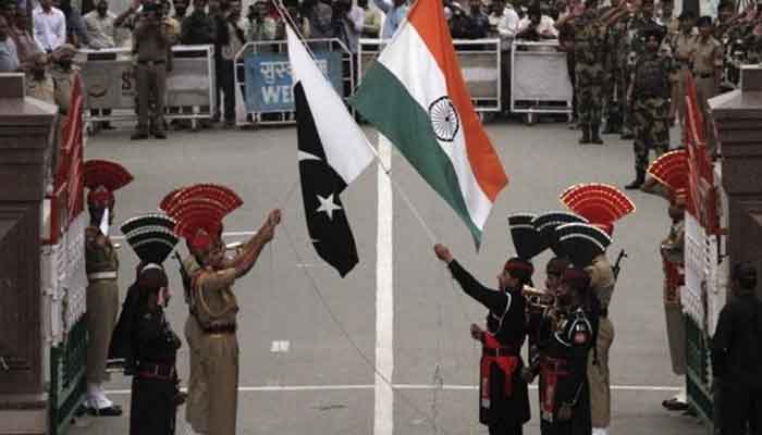 Pakistani rangers (wearing black uniforms) and Indian Border Security Force (BSF) officers lower their national flags during a daily parade at the Pakistan-India joint check-post at Wagah border, near Lahore November 3, 2014. — Reuters