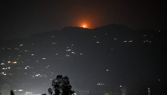 A flare goes up in air over the hill near main town of Poonch district, on May 7, 2025. — AFP