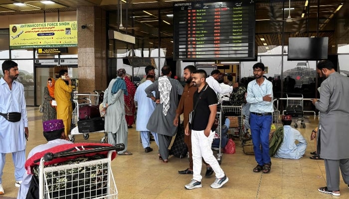 Passengers wait at Jinnah International Airport after all domestic and international flights were cancelled in Karachi on May 7, 2025. — AFP