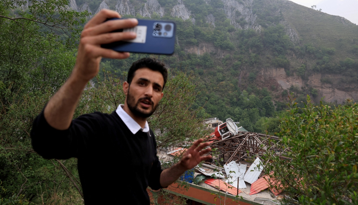 A media person films next to a damaged portion of Bilal Mosque after it was hit by an Indian strike in Muzaffarabad, the capital of Azad Jammu and Kashmir, on May 7, 2025. —Reuters