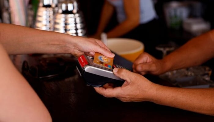 This representational image shows a woman paying with a credit card at a restaurant in Playa del Ingles, Maspalomas on the island of Gran Canaria, Spain, May 3, 2022. — Reuters