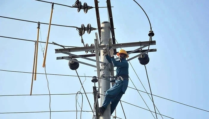 A Fesco worker fixes a line on an electric pole on December 19, 2022. — APP