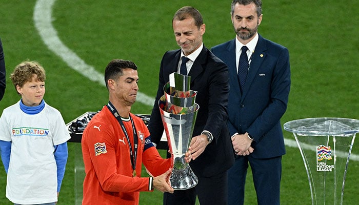 Portugals Cristiano Ronaldo collects the trophy from UEFA president Aleksander Ceferin after winning the Nations League on June 8, 2025. — Reuters