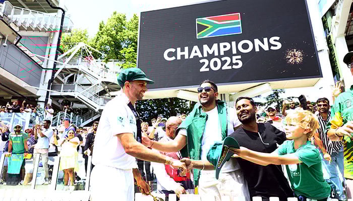 South Africas Keshav Maharaj shakes hands with fans in the stands as a giant screen displays the message of Champions 2025 after South Africa won the ICC World Test Championship final against Australia  at the Lords Cricket Ground in London, UK on June 14, 2025. — Reuters
