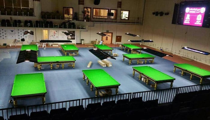 A snooker arena featuring multiple well-lit tables in a hall. — Facebook/Pakistan Billiards & Snooker Association