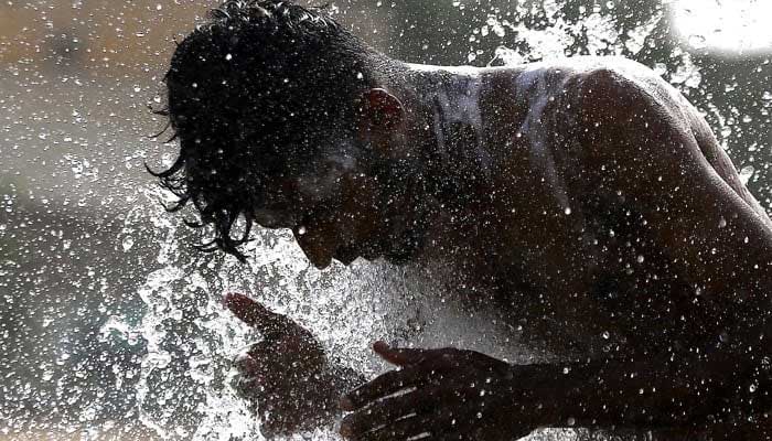 A man cools off at roadside as heatwave continues in Karachi. — INP/File