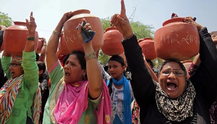Women carrying earthen pitchers on their heads shout slogans during a protest against the shortage of drinking water outside the municipal corporation office in Ahmedabad, India, May 16, 2019. — Reuters
