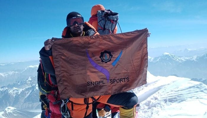 Ashraf Sadpara holds flag of SNGPL sports. — Reporter