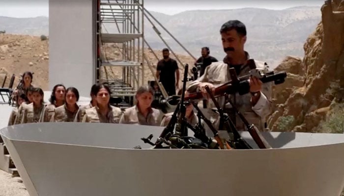 An armed PKK fighter places a weapon to be burnt during a disarming ceremony in Sulaimaniya, Iraq, July 11, 2025. — Reuters
