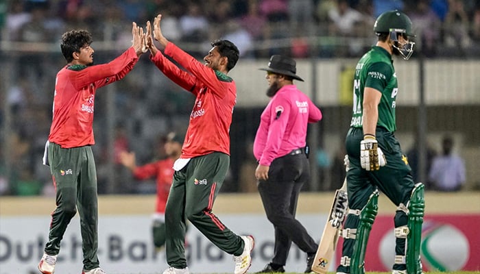 Bangladeshs Mahedi Hasan (L) celebrates with a teammate after taking the wicket of Pakistans captain Salman Agha (R) during the second T20I match against Pakistan at the Sher-e-Bangla National Cricket Stadium in Dhaka on July 22, 2025. — AFP