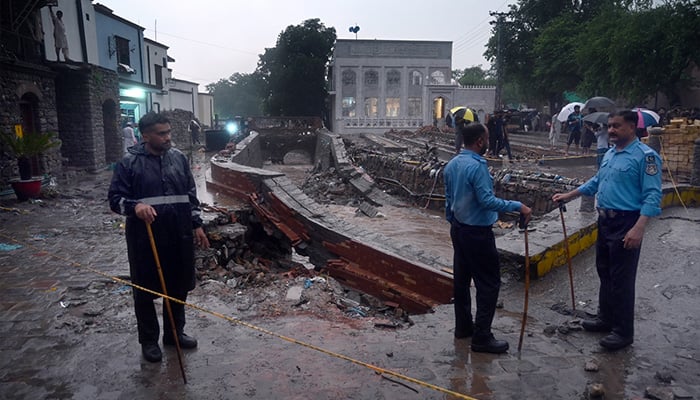 Policemen cordon off area to restrict public access after boundary wall of nullah in Saidpur Village collapsed due to flooding caused by heavy rainfall in Islamabad. — APP/File