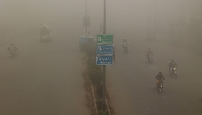 People commute on a smoggy morning in Peshawar. — Reuters/File