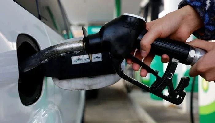 Representational image shows a person using a fuel nozzle to fuel up a car at a petrol station in Vienna, Austria March 18, 2022. — Reuters